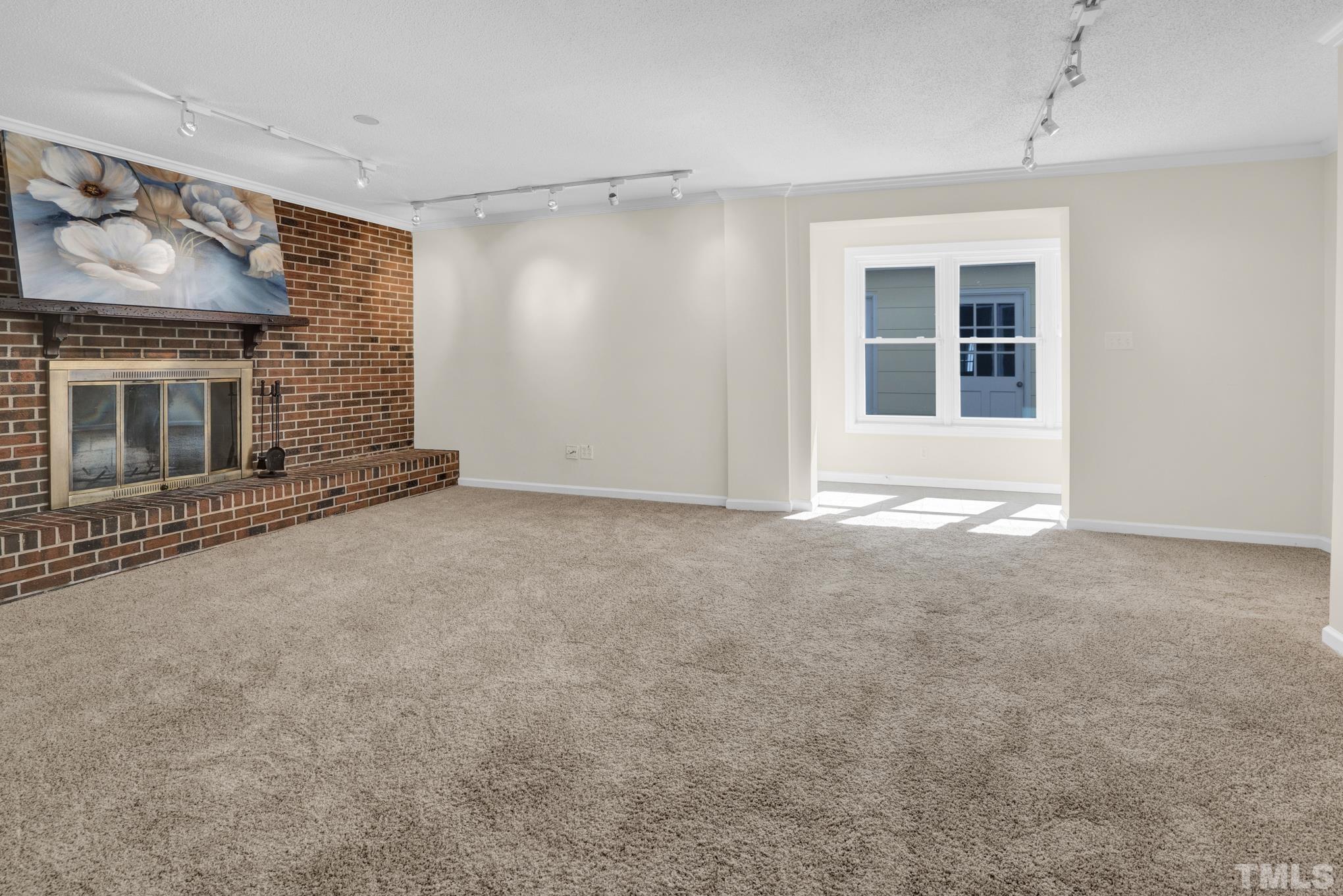 3321 Harden Road Raleigh, NC 27607 - Photo 8 of 26 a view of an empty room with a fireplace and a window