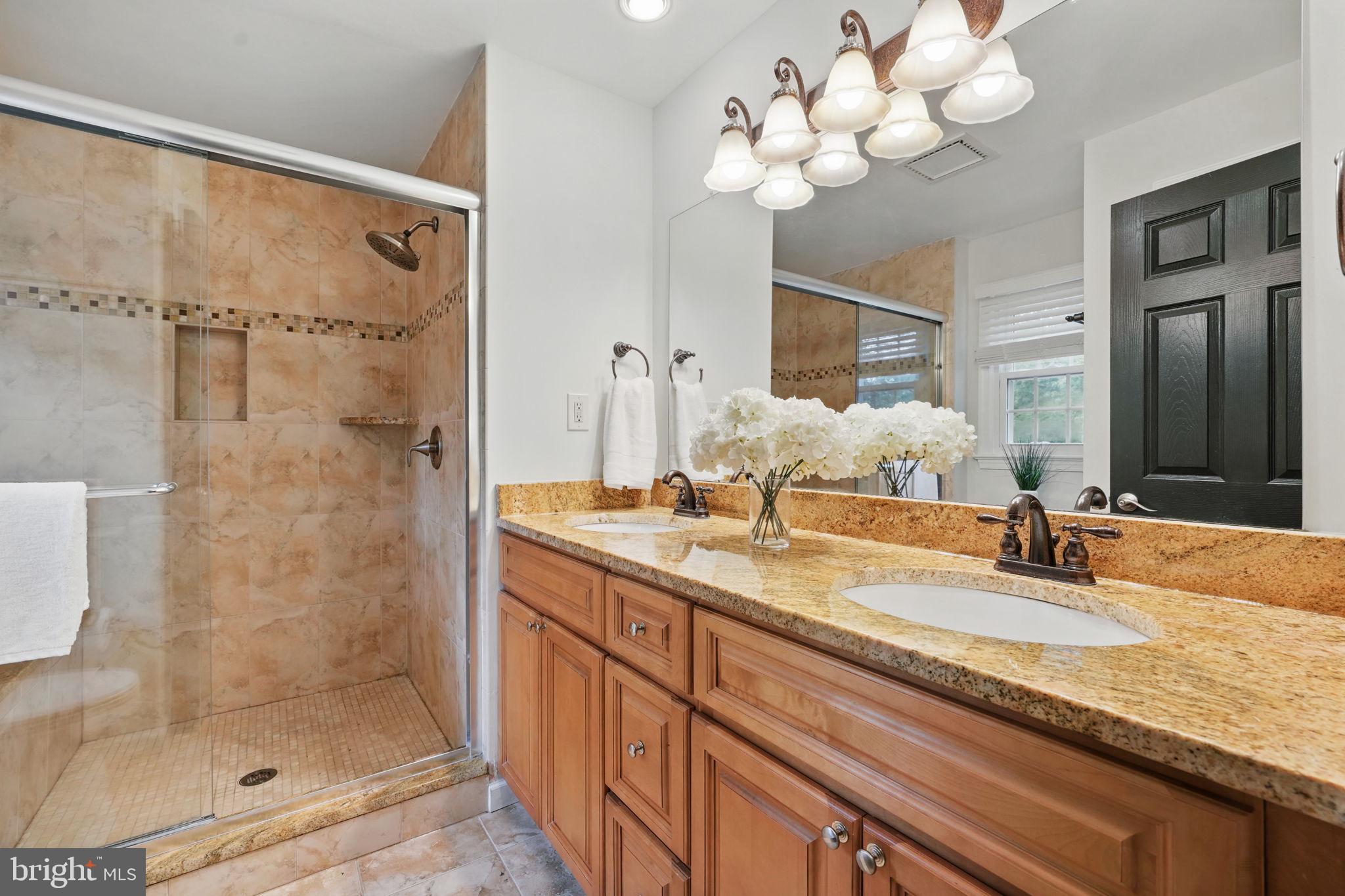 11340 Waples Mill Road Oakton, VA 22124 - Photo 13 of 34 a bathroom with a granite countertop sink a large mirror and a shower