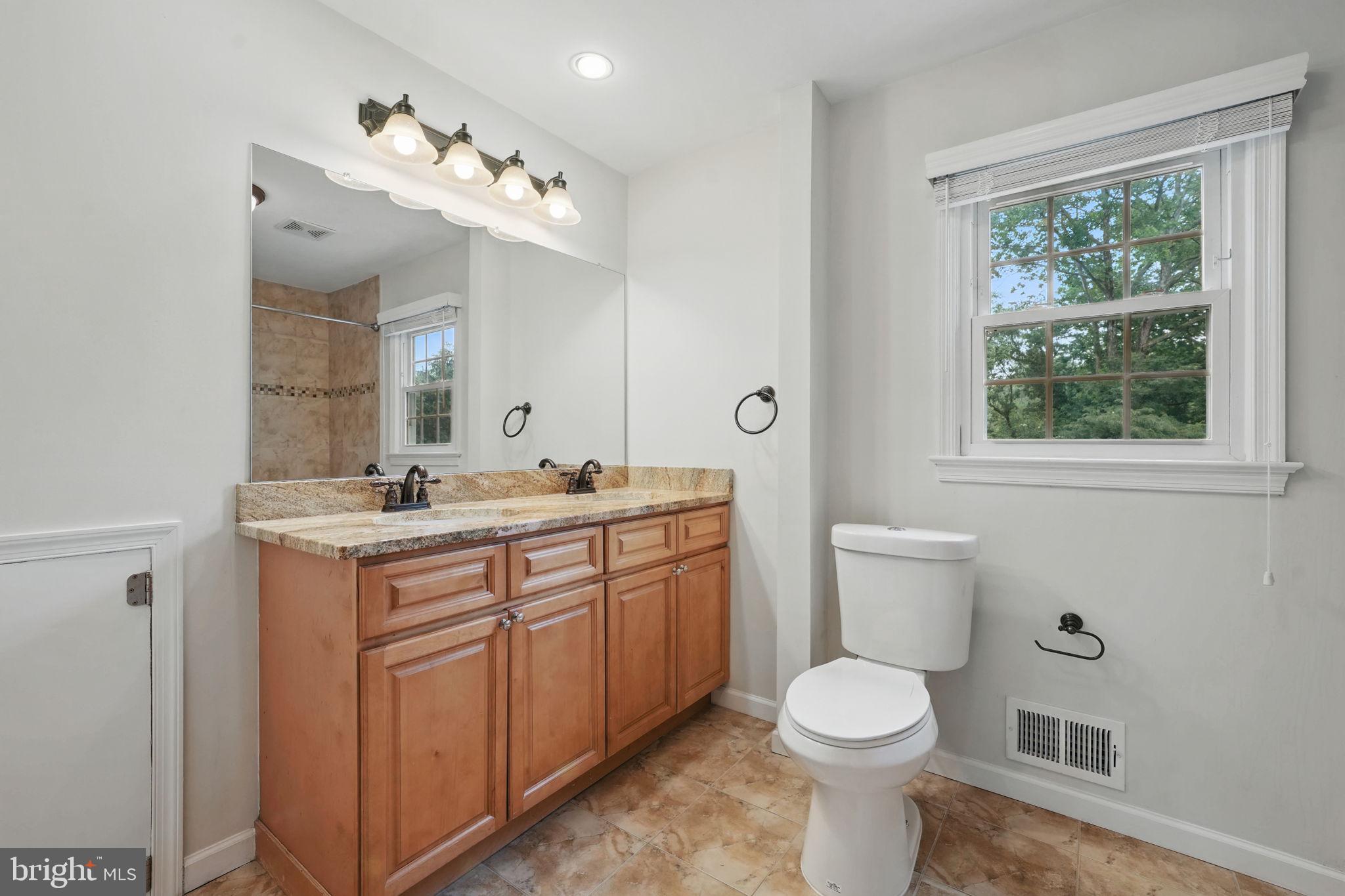 11340 Waples Mill Road Oakton, VA 22124 - Photo 18 of 34 a bathroom with a toilet sink and mirror with window