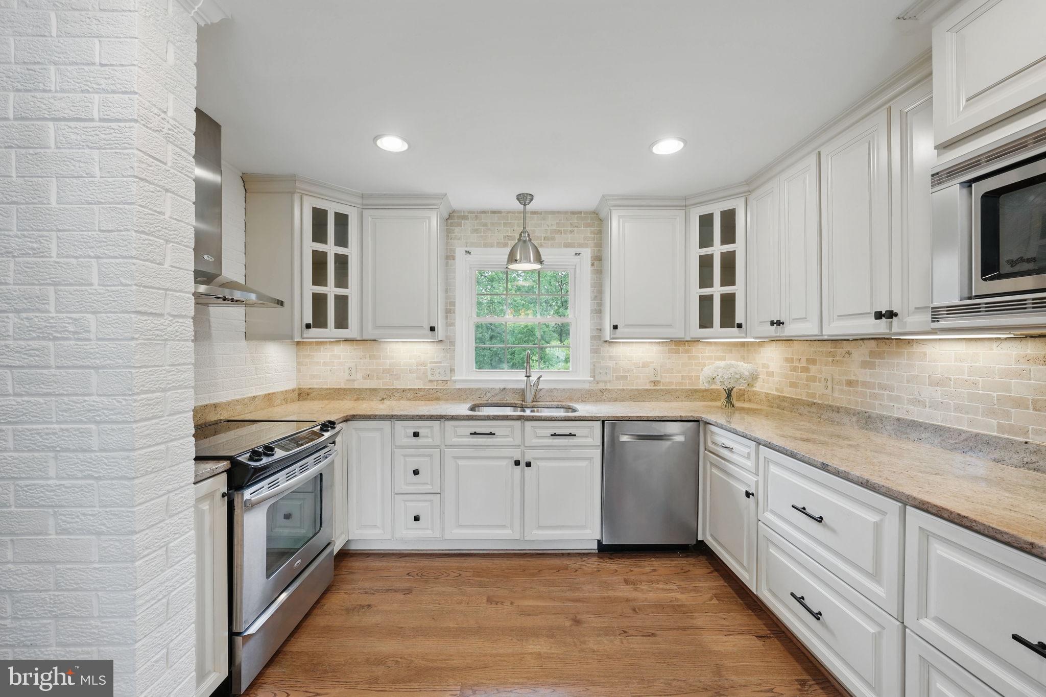 11340 Waples Mill Road Oakton, VA 22124 - Photo 7 of 34 a kitchen with granite countertop white cabinets white stainless steel appliances with a sink and dishwasher