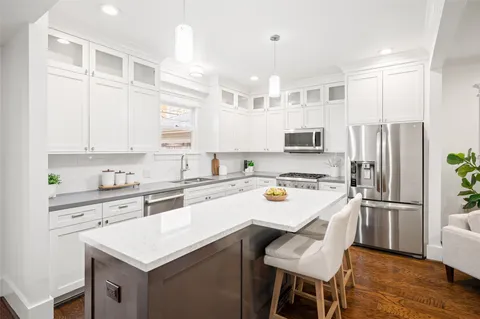 a kitchen with kitchen island granite countertop a sink stainless steel appliances and cabinets