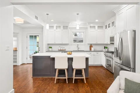 a kitchen with white cabinets and stainless steel appliances