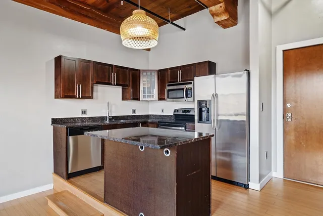 a kitchen with stainless steel appliances granite countertop a stove a refrigerator and a sink