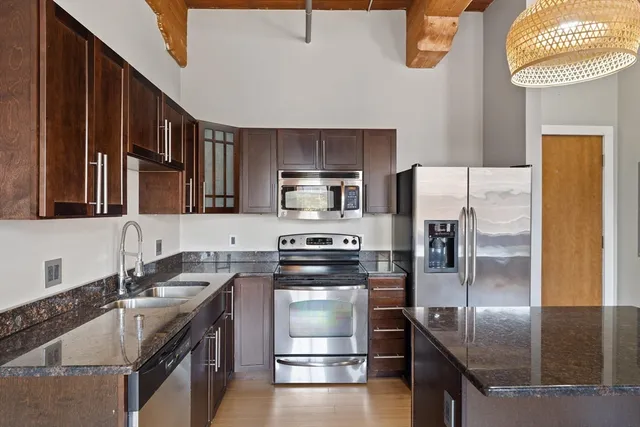 a kitchen with stainless steel appliances granite countertop a stove a refrigerator and a sink