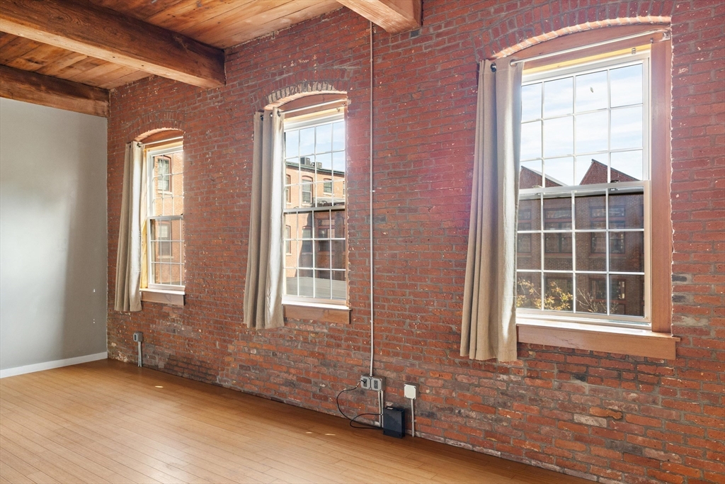 1511 Main Street, Unit C306 Worcester, MA 01603 - Photo 17 of 33 an empty room with wooden floor and windows