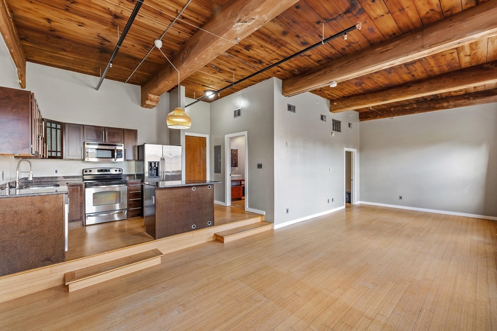 1511 Main Street, Unit C306 Worcester, MA 01603 - Photo 20 of 33 a view of a kitchen with stainless steel appliances granite countertop a stove a refrigerator a sink and dishwasher with wooden floor
