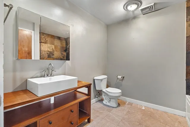 a bathroom with a sink a toilet and mirror