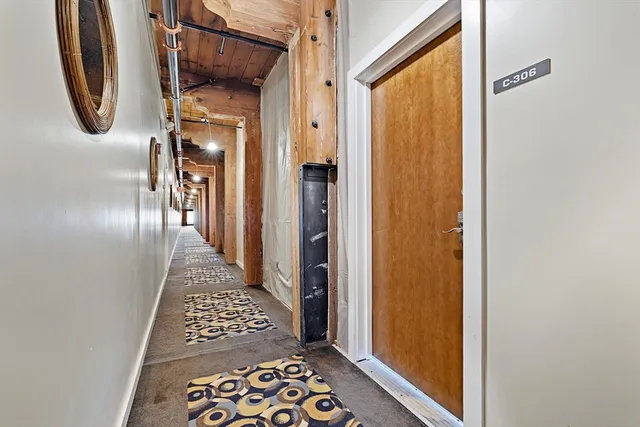 a view of a hallway with wooden floor and glass door