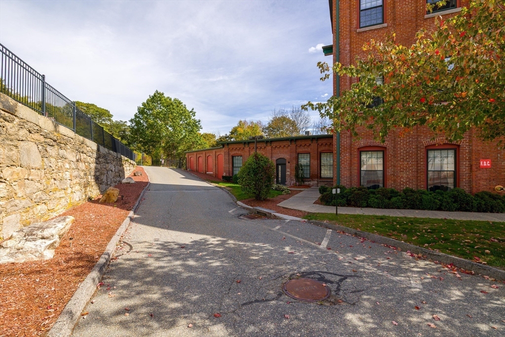 1511 Main Street, Unit C306 Worcester, MA 01603 - Photo 32 of 33 a view of a white house next to a yard with big trees