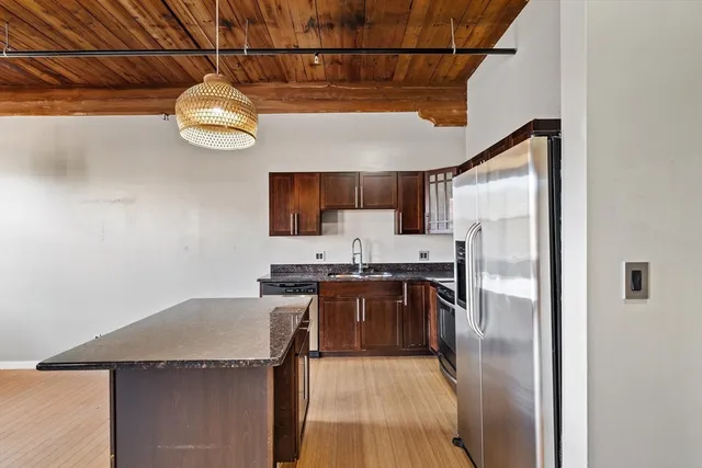 a kitchen with stainless steel appliances a stove refrigerator and a microwave