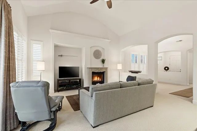 a living room with furniture and a view of kitchen