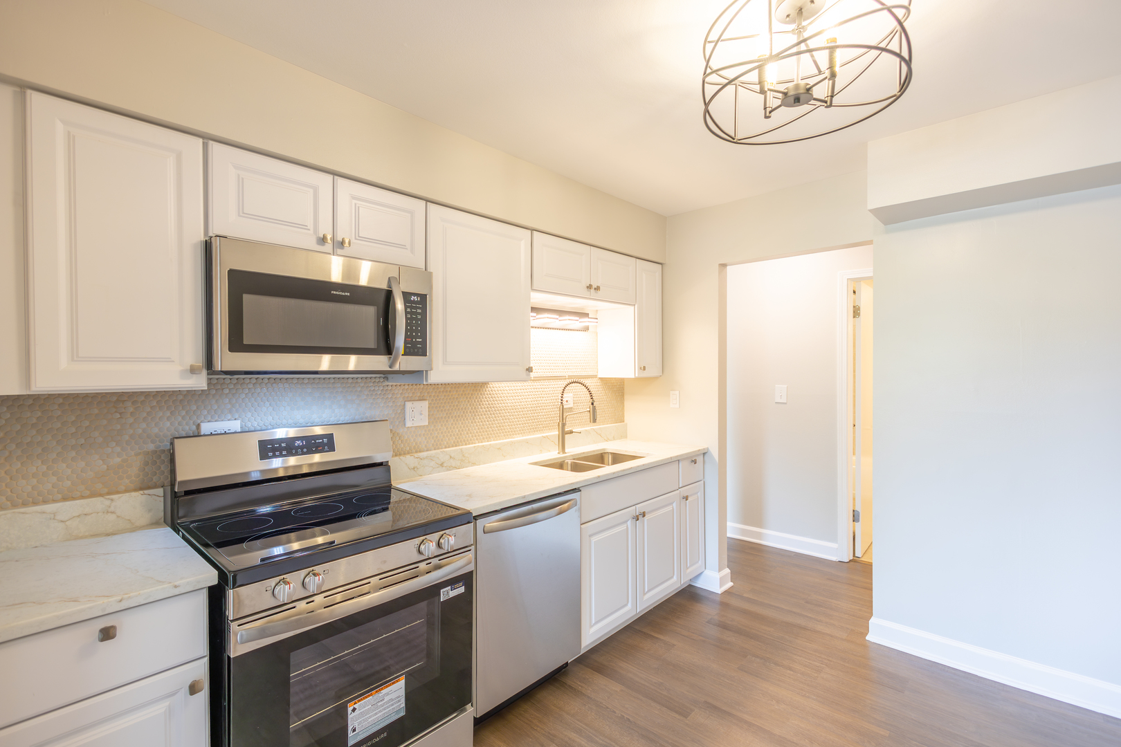 450 Raintree Court, Unit 2B Glen Ellyn, IL 60137 - Photo 9 of 28 a kitchen with stainless steel appliances a stove microwave and sink