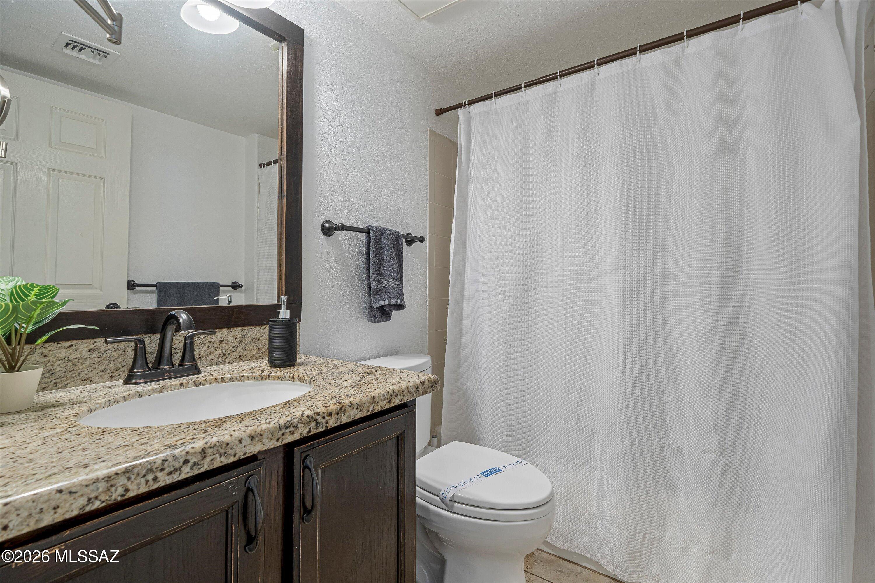 5800 North Kolb Road, Unit 5125 Tucson, AZ 85750 - Photo 19 of 34 a bathroom with a granite countertop sink and a mirror