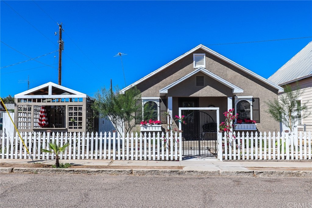 304 C Street Needles, CA 92363 - Photo 1 of 57 a front view of a house with a fence