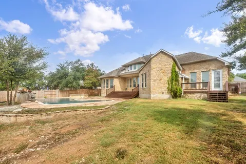a view of a house with a big yard and large trees