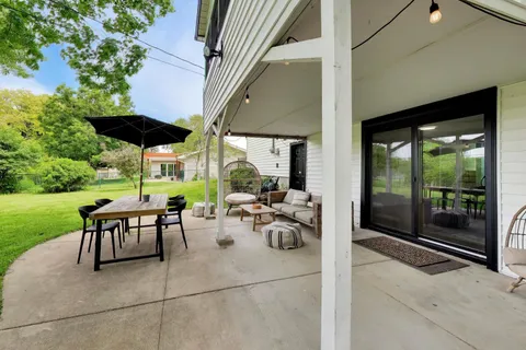 a view of a patio with a table and chairs and potted plants
