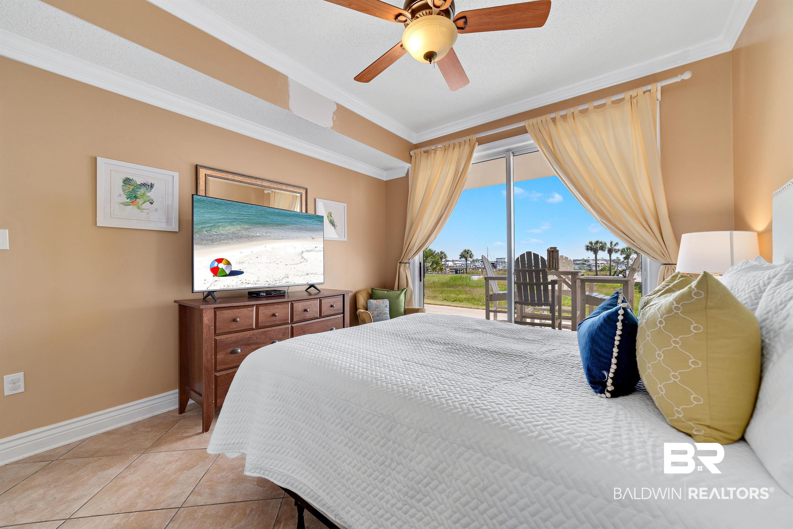 27282 Canal Road, Unit 110 Orange Beach, AL 36561 - Photo 19 of 62 Bedroom with access to exterior, light tile patterned flooring, ornamental molding, and baseboards
