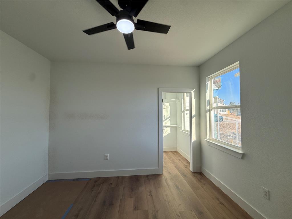 5803 Plum Dale Road Dallas, TX 75241 - Photo 8 of 14 an empty room with wooden floor fan and windows
