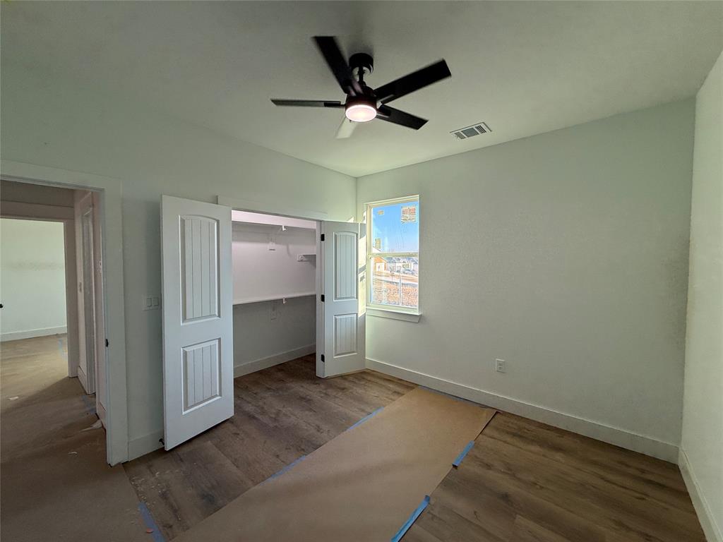 5803 Plum Dale Road Dallas, TX 75241 - Photo 9 of 14 an empty room with windows and a ceiling fan