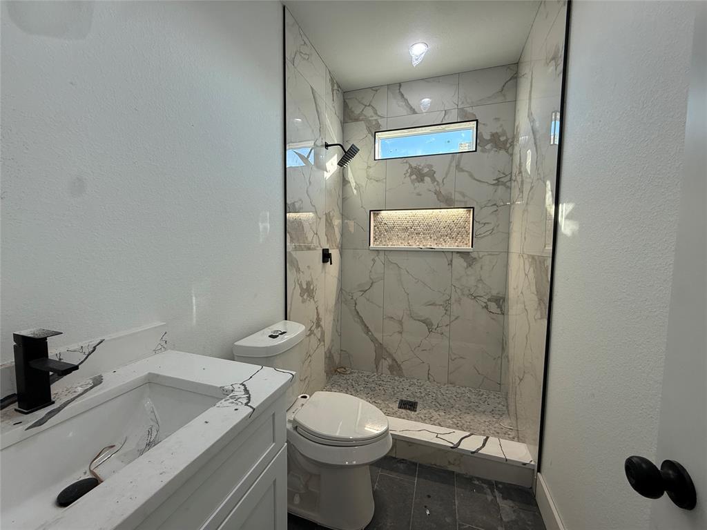 5803 Plum Dale Road Dallas, TX 75241 - Photo 10 of 14 a bathroom with a sink toilet and shower