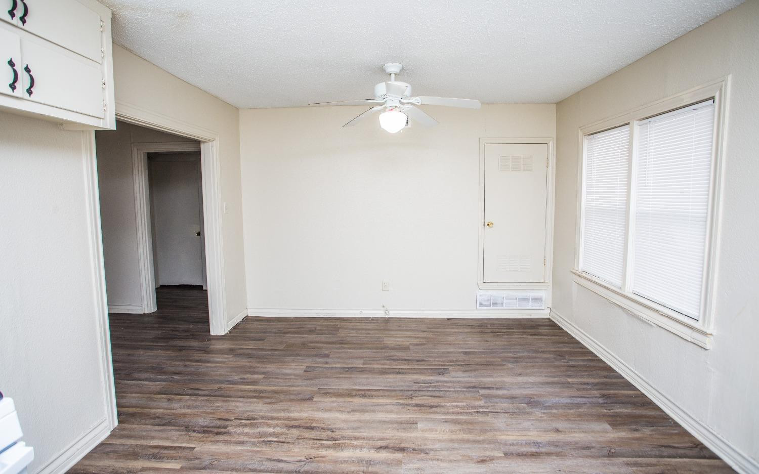 2103 22nd Street Lubbock, TX 79411 - Photo 3 of 18 a view of an empty room with wooden floor and a window