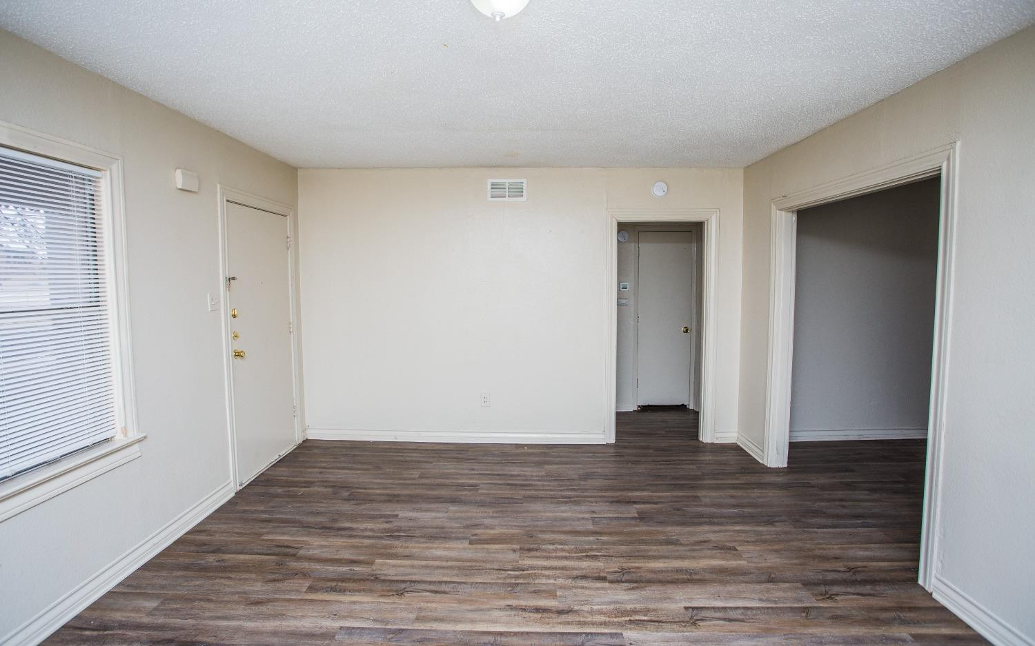 2103 22nd Street Lubbock, TX 79411 - Photo 7 of 18 a view of an empty room with wooden floor and closet