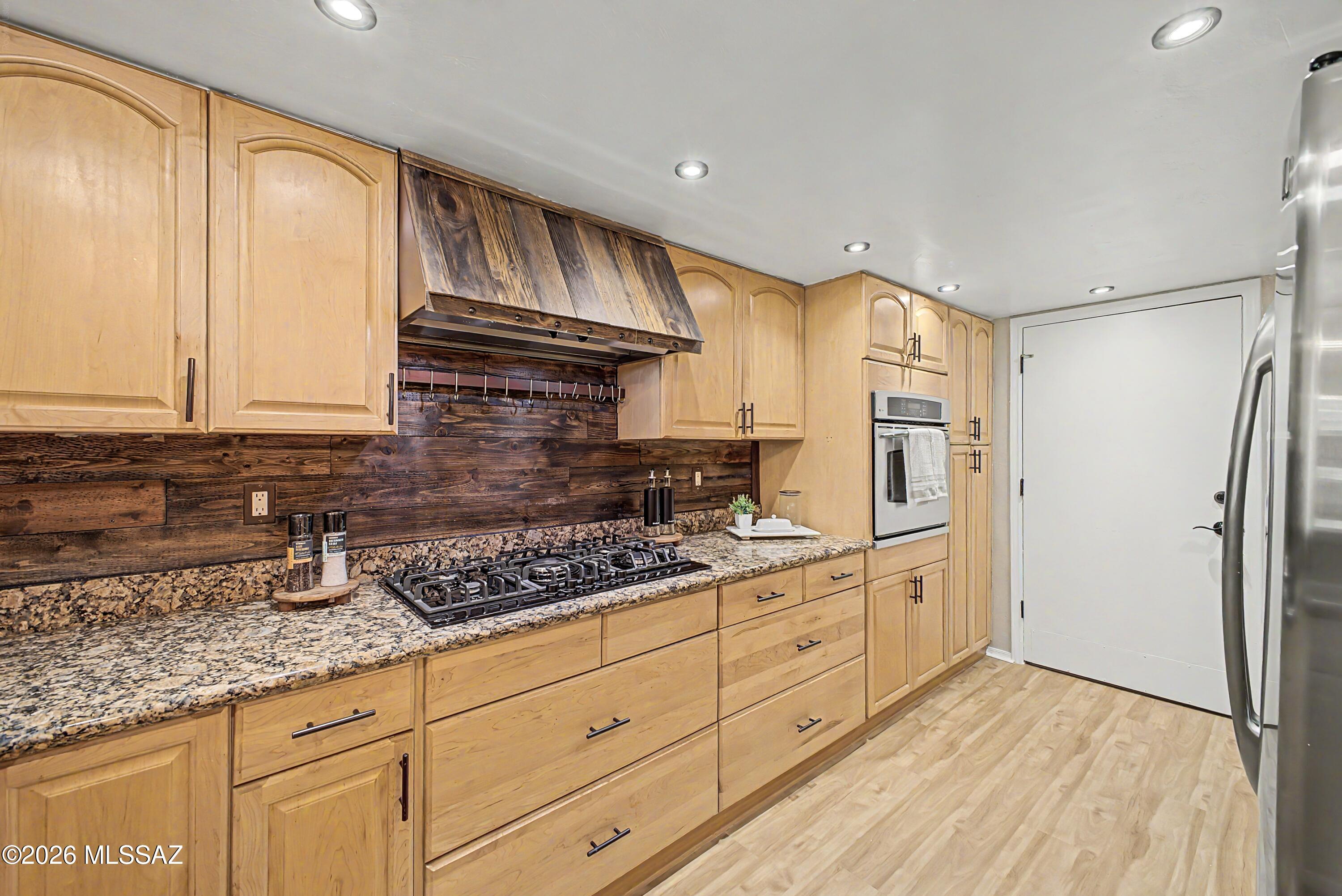 3781 East Edison Street Tucson, AZ 85716 - Photo 9 of 28 a kitchen with granite countertop white cabinets and stainless steel appliances