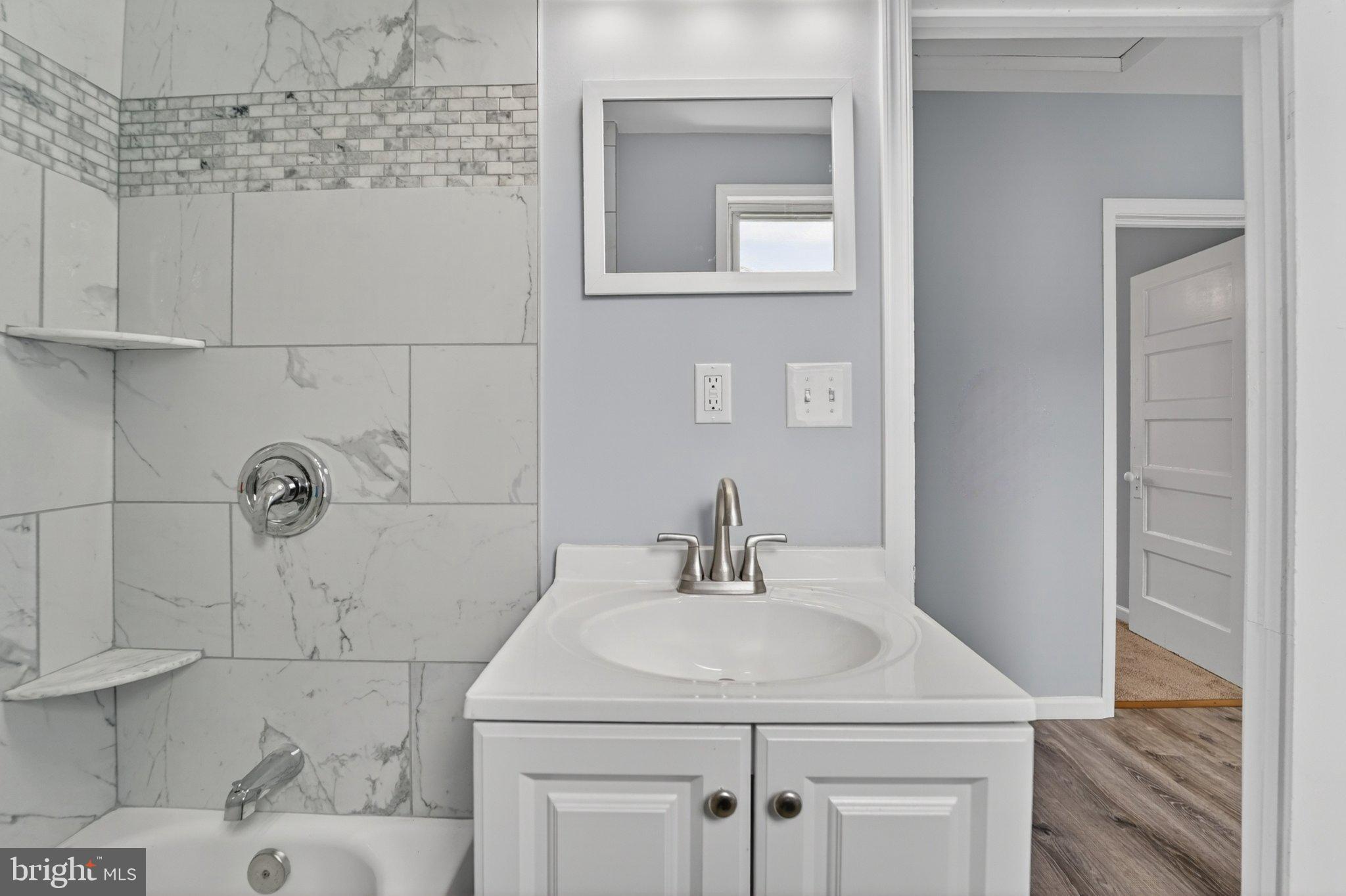 5312 Catalpha Road Baltimore, MD 21214 - Photo 55 of 59 a bathroom with a sink a vanity and mirror