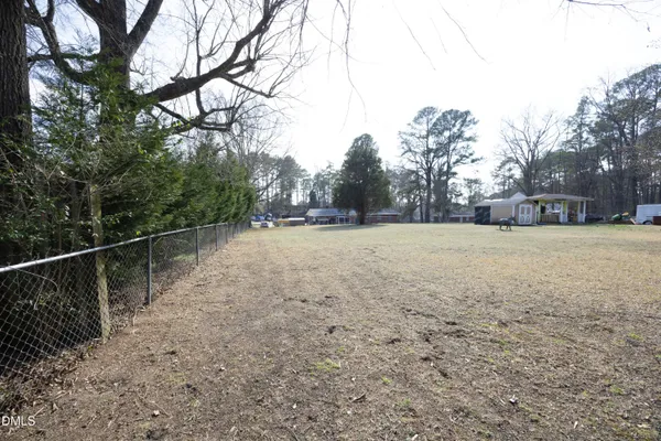 a view of a yard with trees in the background