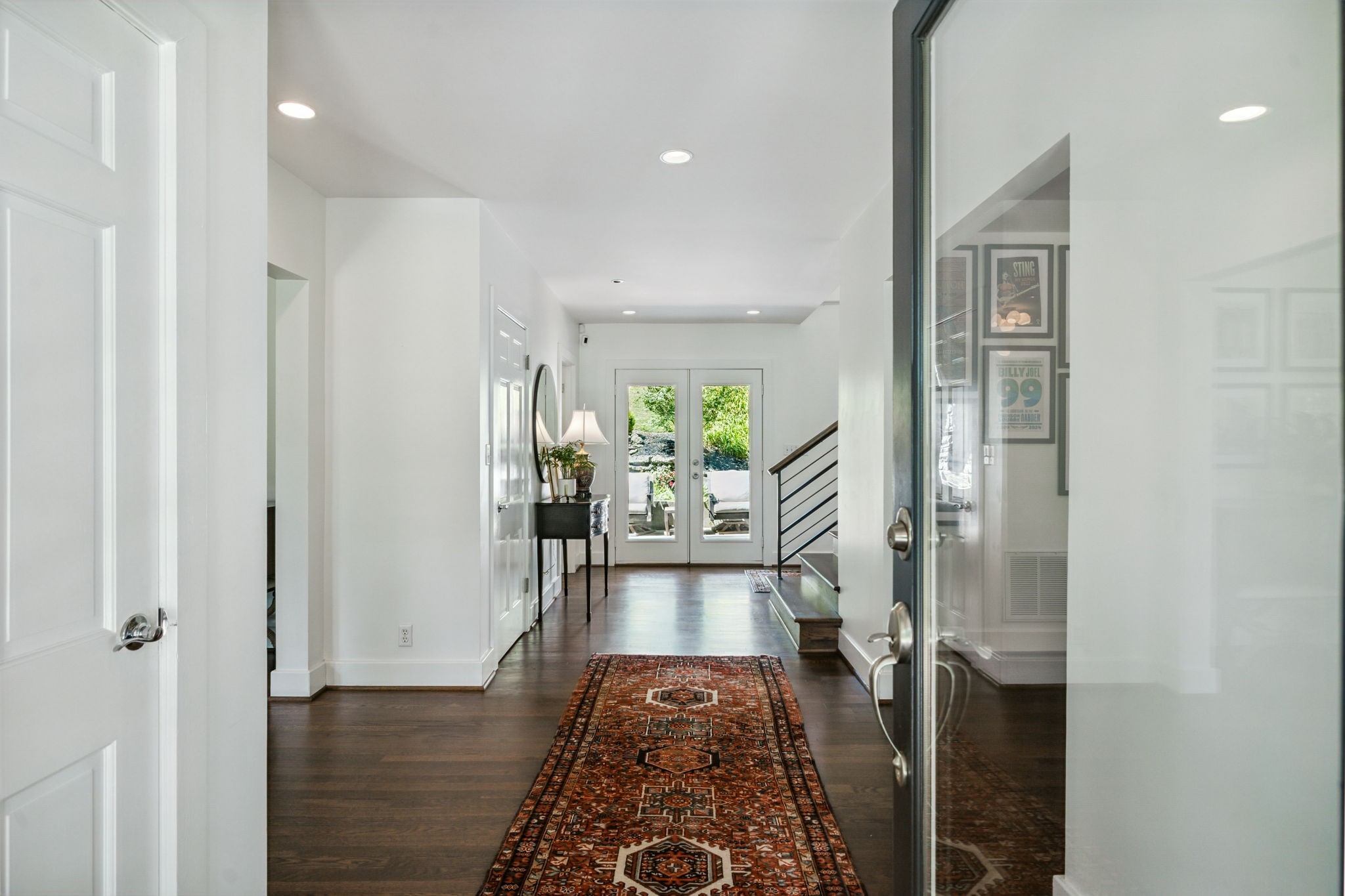 915 Overton Lea Road Nashville, TN 37220 - Photo 10 of 75 a view of a hallway with wooden floor a chandelier and a living room