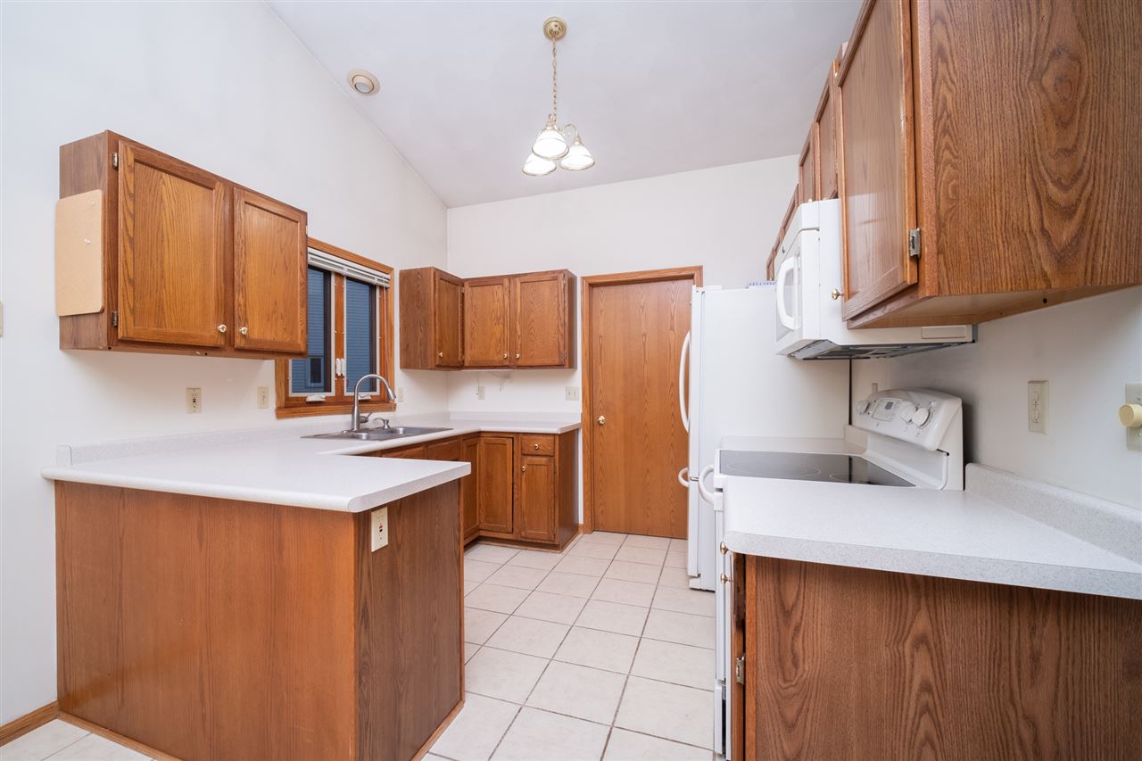 6614 North Point Road Rockford, IL 61108 - Photo 7 of 26 a kitchen with stainless steel appliances a sink a stove a refrigerator cabinets and a window