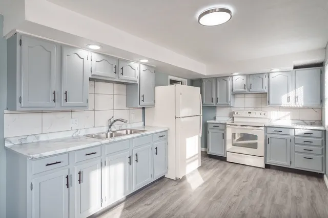 a kitchen with white cabinets and white appliances