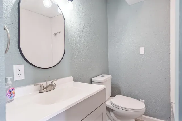 a bathroom with a sink a toilet and a mirror