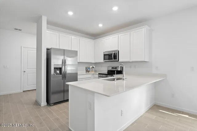a kitchen with appliances a sink and a refrigerator