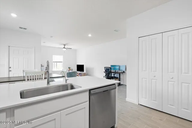 a kitchen with a sink and white cabinets