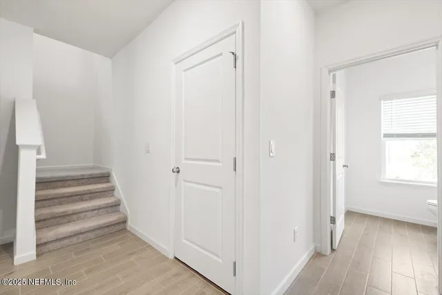 a view of a hallway with wooden floor and entryway