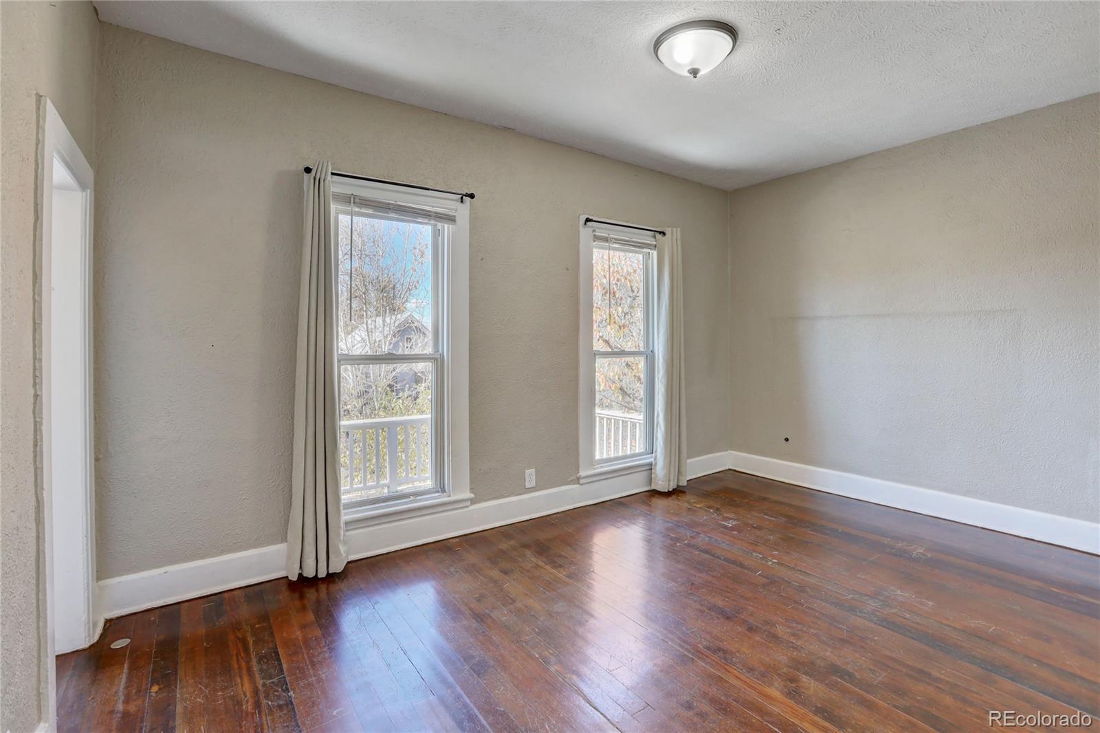 418 Inca Street Denver, CO 80204 - Photo 18 of 24 an empty room with wooden floor and windows