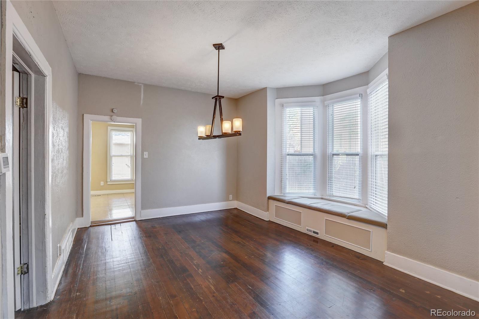 418 Inca Street Denver, CO 80204 - Photo 4 of 24 a view of empty room with wooden floor and window