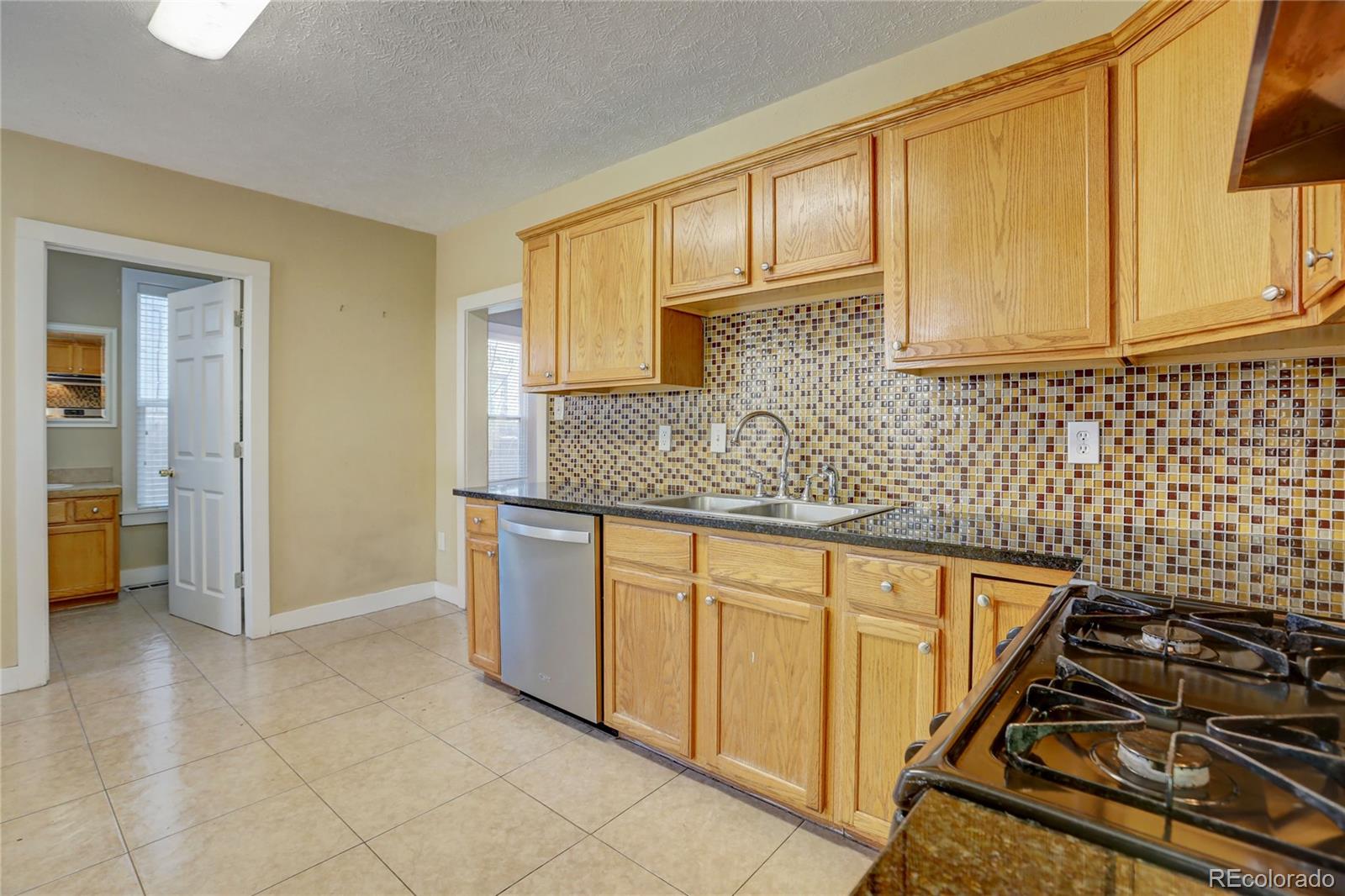 418 Inca Street Denver, CO 80204 - Photo 6 of 24 a kitchen with stainless steel appliances granite countertop a sink stove and cabinets