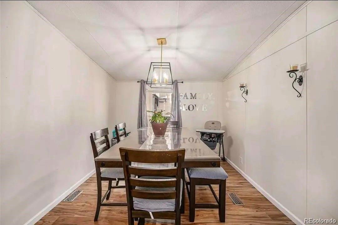 9595 North Pecos Street Thornton, CO 80260 - Photo 3 of 7 a view of a dining room with furniture and wooden floor