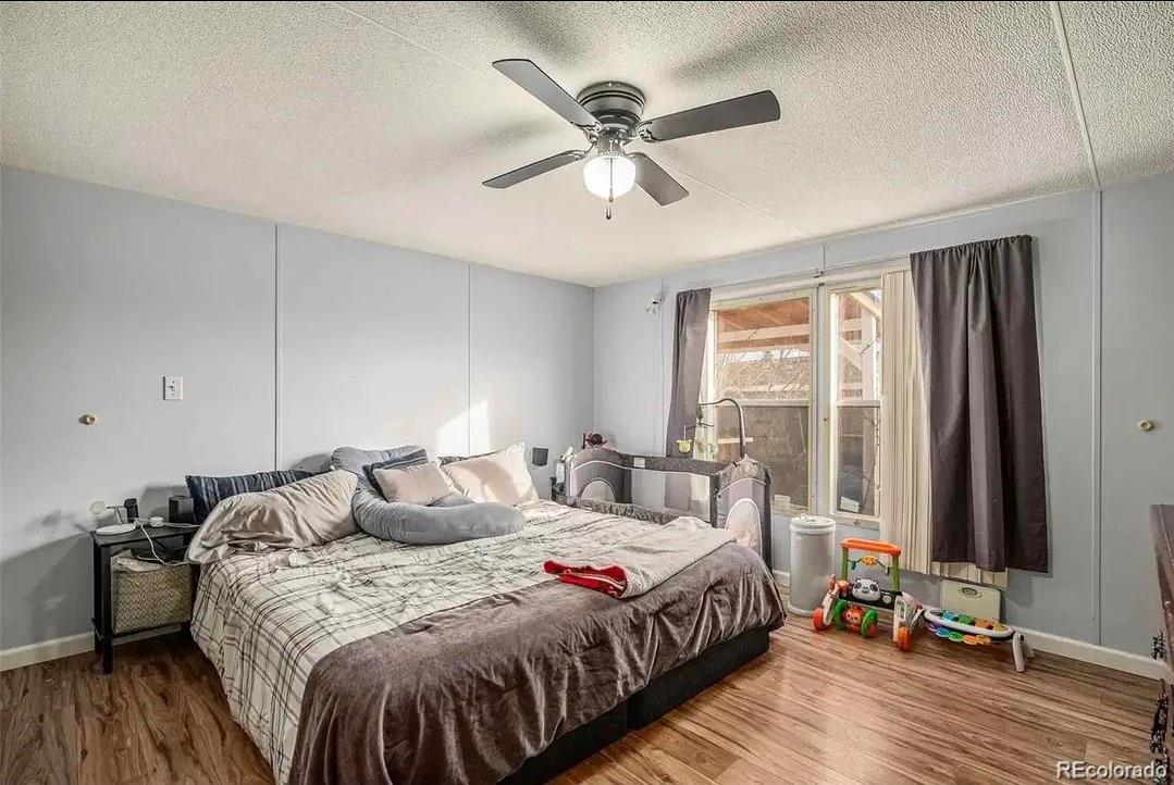 9595 North Pecos Street Thornton, CO 80260 - Photo 4 of 7 a bedroom with a bed and wooden floor