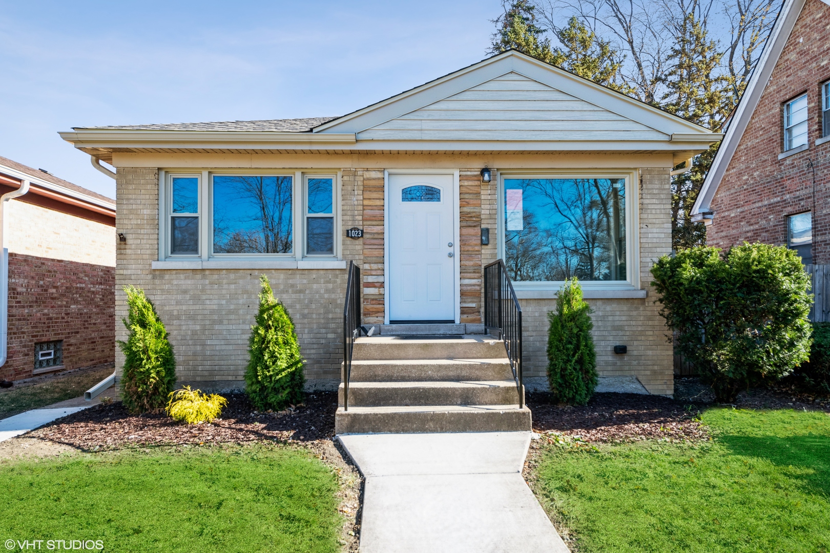 a front view of a house with a garden and plants