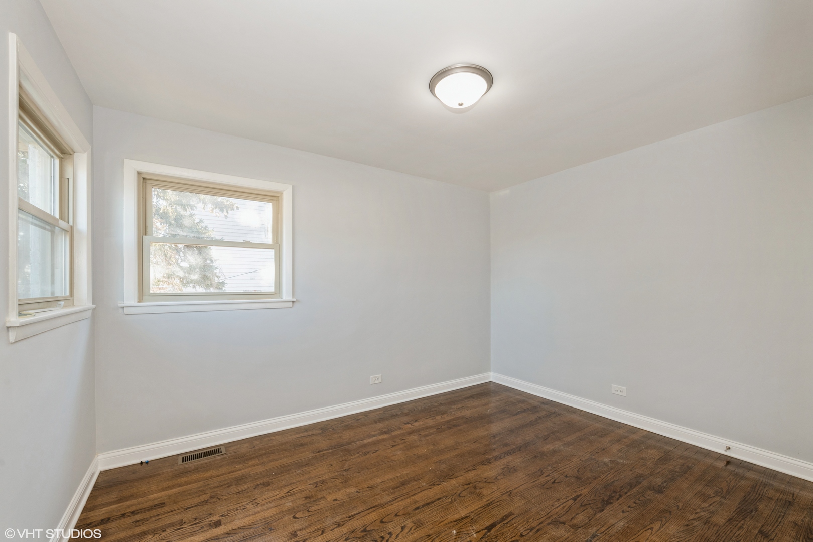 1023 Rice Avenue Bellwood, IL 60104 - Photo 10 of 12 an empty room with wooden floor and windows