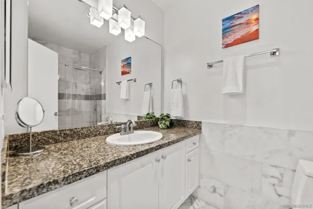 a bathroom with a granite countertop double vanity sink and a mirror
