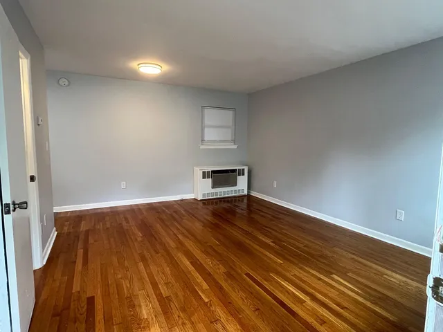 a view of a room with wooden floor and window
