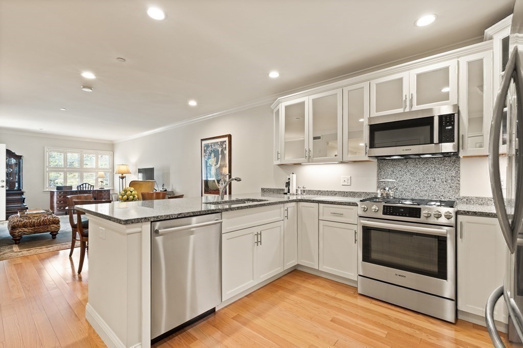 2 Manor Terrace, Unit 209 Lexington, MA 02420 - Photo 13 of 26 a kitchen with stainless steel appliances granite countertop a stove top oven a sink and a microwave