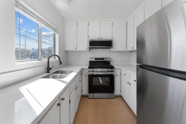 a kitchen with white cabinets and stainless steel appliances