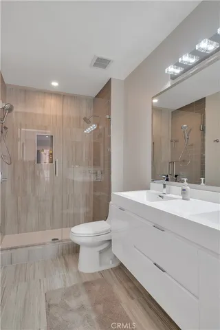 a bathroom with a double vanity sink toilet and shower