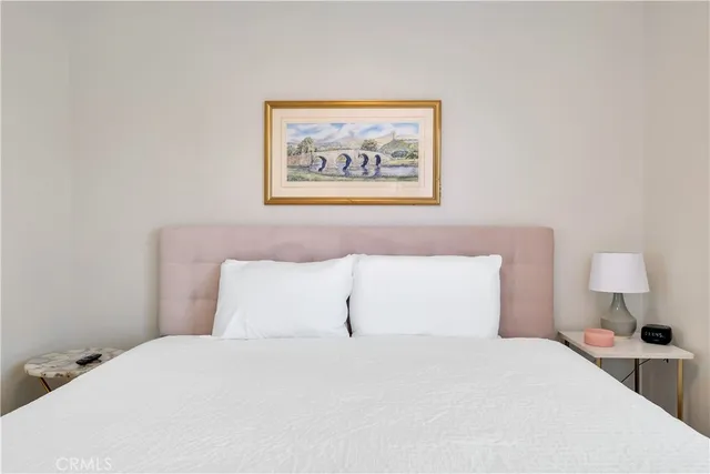 a bedroom with a bed and a painting on the wall