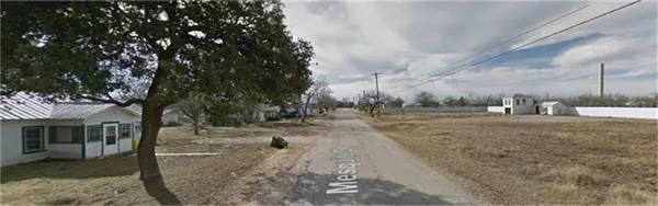 a view of a dry yard with trees